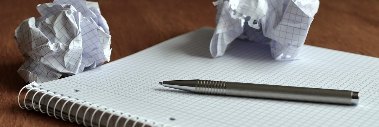Crumpled up paper on a notebook with a pen. MaxPixel CC0